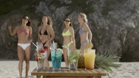 Kalte,-Erfrischende-Cocktails-Auf-Dem-Tisch-Und-Tanzende-Mädchen-Am-Strand